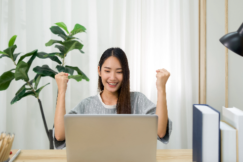 student excited on laptop